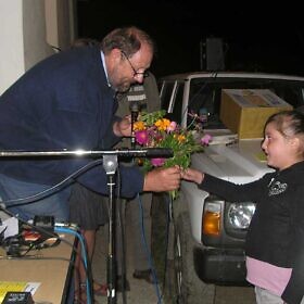 Frieder Weinhold bekommt einen Blumenstrauß von der Familie Lapushai geschenkt